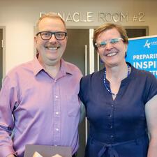 Male retiree stands and smiles with his female guest